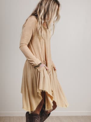 Woman wearing a beige dress with a plain background