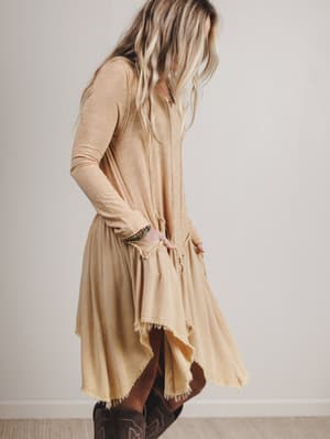 Woman wearing a beige dress with a plain background