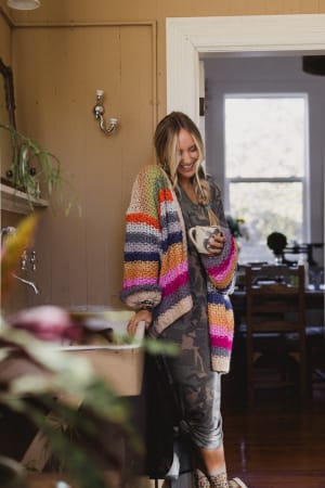 Woman wearing a colorful cardigan in a home setting