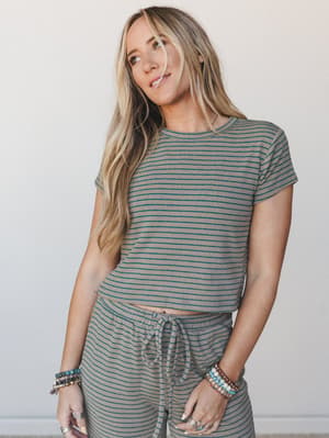 A matching ribbed stripe set in warm taupe and teal — the kind of effortless two-piece that blurs the line between 'running errands' and 'actually put-together,' styled with stacked beaded bracelets and rings for that lived-in boho feel.
