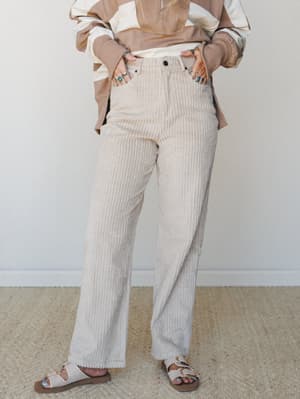Wide-leg corduroy pants in a soft sandstone khaki styled with a color-block pullover and buckle sandals — the kind of relaxed, put-together look that feels intentional without trying too hard.