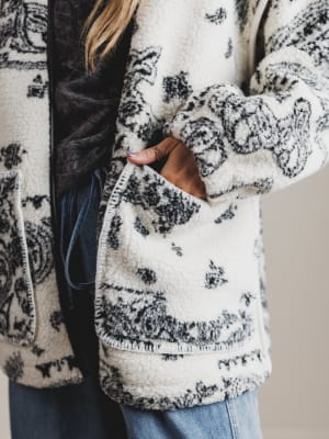 Close-up of a person wearing a patterned coat with a neutral background