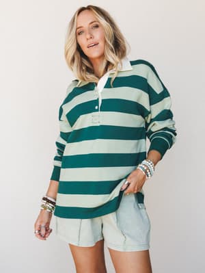 An oversized rugby-stripe polo top in hunter green and mint worn with light wash shorts and stacked bead bracelets — the kind of outfit that looks like it took zero effort and somehow that's the whole point.