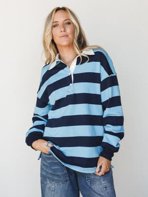 An oversized rugby-stripe polo top in sky blue and navy pairs with wide-leg cargo denim for a relaxed, throwback-cool look that feels effortless without trying.