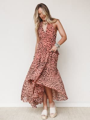 A flowy leopard-print maxi dress in dusty rose and brown styled with stacked turquoise bracelets and platform espadrilles — the kind of dress that moves when you walk and makes people ask where you got it.