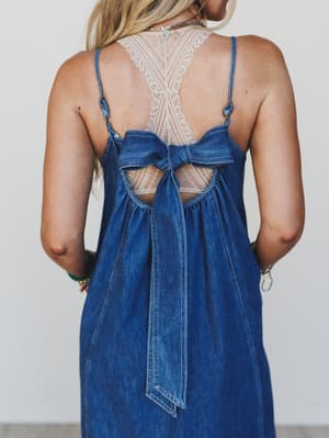 Blue denim dress with lace back on a plain background