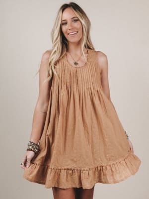Woman wearing a brown dress against a plain background