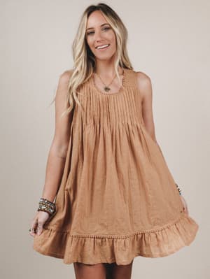 Woman wearing a brown dress against a plain background