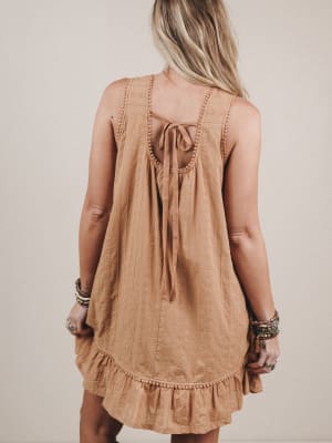 Woman wearing a brown dress with a beige background