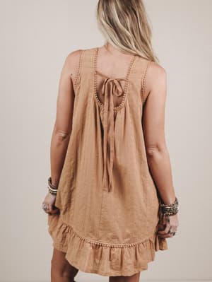 Woman wearing a brown dress with a beige background