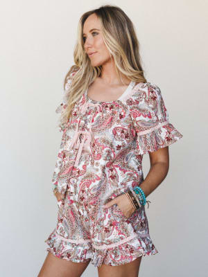 A breezy paisley matching set — flowy top and ruffle-hem shorts — styled with stacked turquoise and gold bracelets, giving off that effortless summer energy that looks intentional without trying too hard.