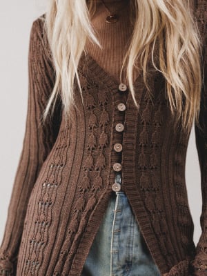 Brown knitted cardigan worn by a person with a neutral background