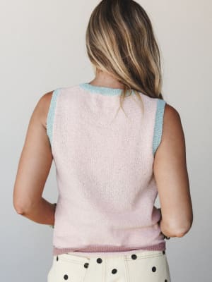 A back-view shot of a soft knit tank in blush pink with contrast mint trim at the neckline and armholes, paired with cream polka dot pants — sweet, vintage-leaning, and quietly playful.