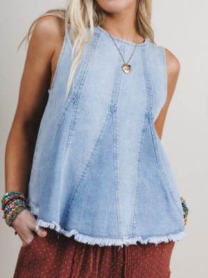Denim sleeveless top worn by a person with a neutral background