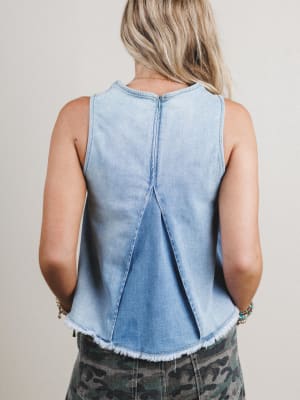 Light blue denim sleeveless top worn by a person on a plain background