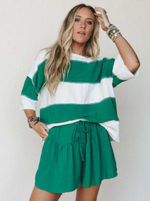 A breezy two-piece matching set in kelly green and ivory — the oversized striped top and ruffled drawstring shorts feel like the kind of outfit you throw on and somehow look completely put-together.