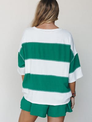 A model shot from behind showing a relaxed oversized striped tee and matching green shorts set — the kind of easy two-piece you reach for on a summer morning without thinking twice.