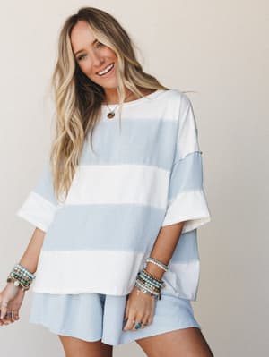 A relaxed matching set in soft sky blue and ivory wide stripes — the kind of outfit that looks like it was effortlessly thrown on but somehow still comes together perfectly, styled with layered boho bracelets and a warm smile.