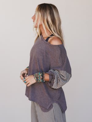 Woman wearing a purple poncho with a plain background