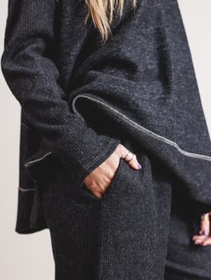 Person wearing a dark gray coat with a neutral background