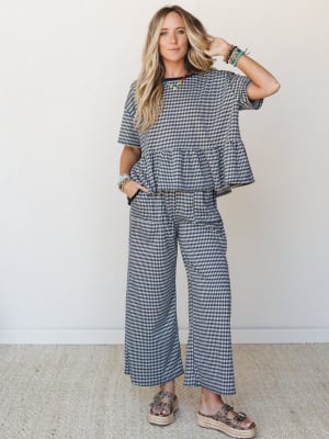 A matching gingham two-piece set styled with stacked beaded bracelets and platform sandals — the kind of outfit that looks intentional without trying too hard.