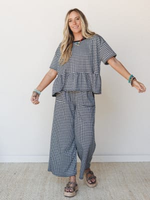 A matching gingham two-piece set styled with layered bead bracelets and espadrille platform sandals — the kind of effortless outfit that looks put-together without trying too hard.