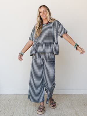 A matching gingham two-piece set styled with layered bead bracelets and espadrille platform sandals — the kind of effortless outfit that looks put-together without trying too hard.