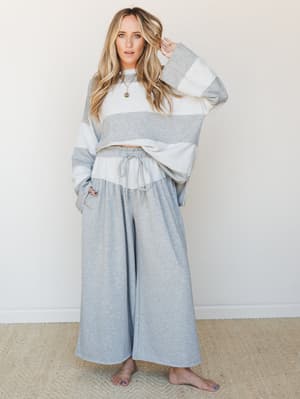 A relaxed, color-blocked sweatshirt and wide-leg palazzo pant set in heathered gray and cream — the kind of outfit that makes staying home feel intentional.
