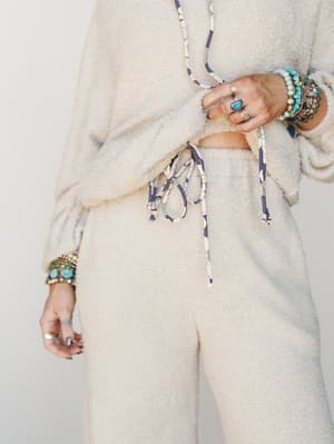 A soft, cream boucle lounge set styled with layers of turquoise and silver boho jewelry — the kind of outfit that makes staying in feel just as intentional as going out.
