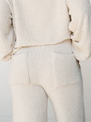 A close-up back view of a cream boucle lounge set — the soft, nubby texture does all the talking, and the tonal pairing of top and pant makes it feel intentional without trying too hard.