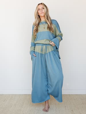 A relaxed two-piece matching set in dusty teal and sage, styled with stacked gold and turquoise jewelry — the kind of outfit that looks intentional whether you're running errands or hosting Sunday brunch.