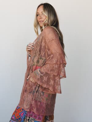 A sheer rose brown lace kimono layered over a colorful printed dress — the kind of piece that makes a whole outfit feel intentional without trying too hard.