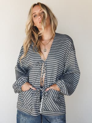 A relaxed gingham cardigan styled open over a lace bralette with wide-leg denim — the kind of effortless, thrown-on look that somehow always comes together perfectly.
