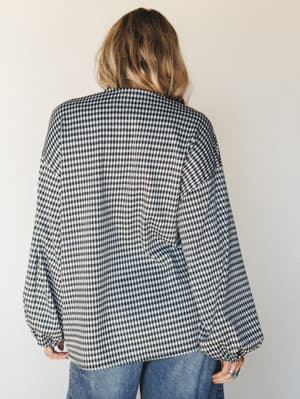 A back-view shot of a relaxed gingham cardigan with balloon sleeves, styled with wide-leg denim — the kind of top that makes a Tuesday feel a little more intentional.