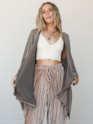 A relaxed, layered boho look built around a draped duster cardigan with wide sleeves, styled over a cream lace bralette and blush striped wide-leg pants — the kind of outfit that feels effortless but clearly wasn't an accident.