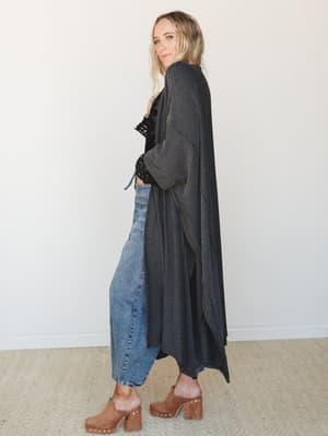 A relaxed full-length duster kimono in charcoal stripe layers effortlessly over a black lace crop top and wide-leg jeans, finished with studded wood clogs — the kind of outfit that looks like you tried just enough.