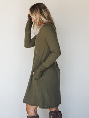 A relaxed ribbed knit dress in dusty olive worn with dark brown cowboy boots — the kind of effortless fall outfit that feels equally at home on a coffee run or a casual dinner out.