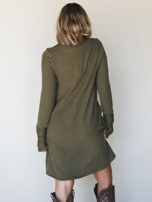 A ribbed mini dress in dusty olive shot from the back, styled with brown cowboy boots — the kind of effortless fall outfit that looks like it took zero effort and somehow all the effort.