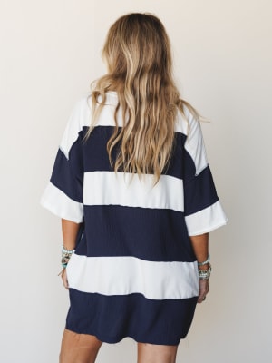 Shot from the back, this oversized navy and white wide-stripe dress has an easy, relaxed feel — styled with stacks of turquoise and silver bracelets that give it just enough personality.