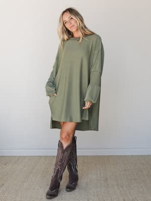 An oversized ribbed mini dress in army green styled with tall dark brown cowboy boots — the kind of effortless outfit that looks like you tried just enough.