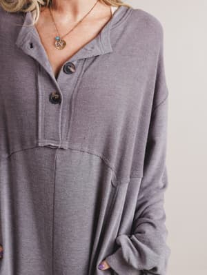 Gray long-sleeve shirt worn by a person with a neutral background