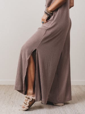 Person wearing a long, flowing dress with a neutral background