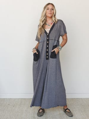 A relaxed maxi-length button-front jumpsuit in heathered gray with charcoal contrast trim and patch pockets, styled with stacked boho jewelry and woven flats for an effortlessly lived-in look.