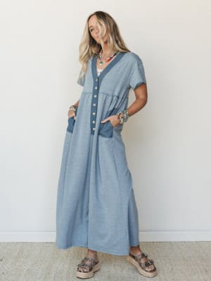 A relaxed maxi-length button-front dress in heathered dusty blue styled with layered beaded necklaces, stacked bracelets, and espadrille platform sandals — the kind of outfit that looks effortless but clearly wasn't an accident.