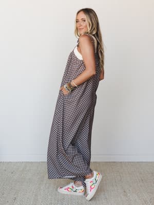 A breezy, full-length printed jumpsuit styled with embroidered sneakers and a stack of beaded bracelets — effortless and a little free-spirited, the kind of outfit that looks like you tried just the right amount.