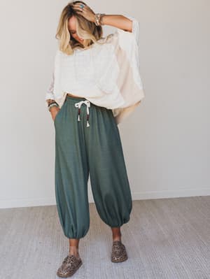 Relaxed harem-style joggers in a muted olive paired with an oversized cream top and leopard flats — the kind of outfit that looks effortless but was absolutely thought about.