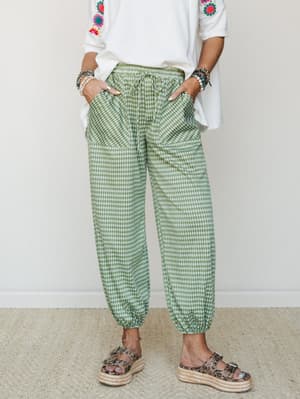 Green gingham jogger pants styled with an embroidered white tee, stacked bracelets, and platform espadrille sandals — relaxed and playful with just enough personality.