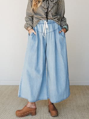 Wide-leg chambray pants with a relaxed drawstring waist styled with a gingham ruffle blouse and wood-studded clogs — the kind of outfit that looks effortless but was absolutely thought about.