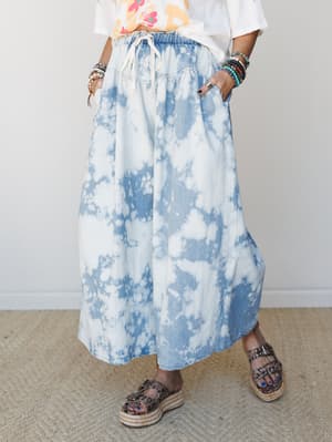 A bleach-dyed denim wide-leg pant styled with a graphic tee and studded espadrille platform sandals — the kind of effortless outfit that looks like it came together without trying, but definitely didn't.