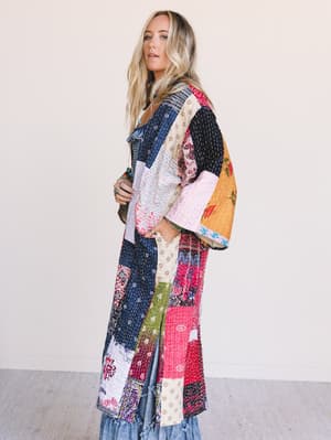 side view of a woman wearing a colorful One-of-a-Kind Stargazer Quilted Kimono in Multi against a plain background